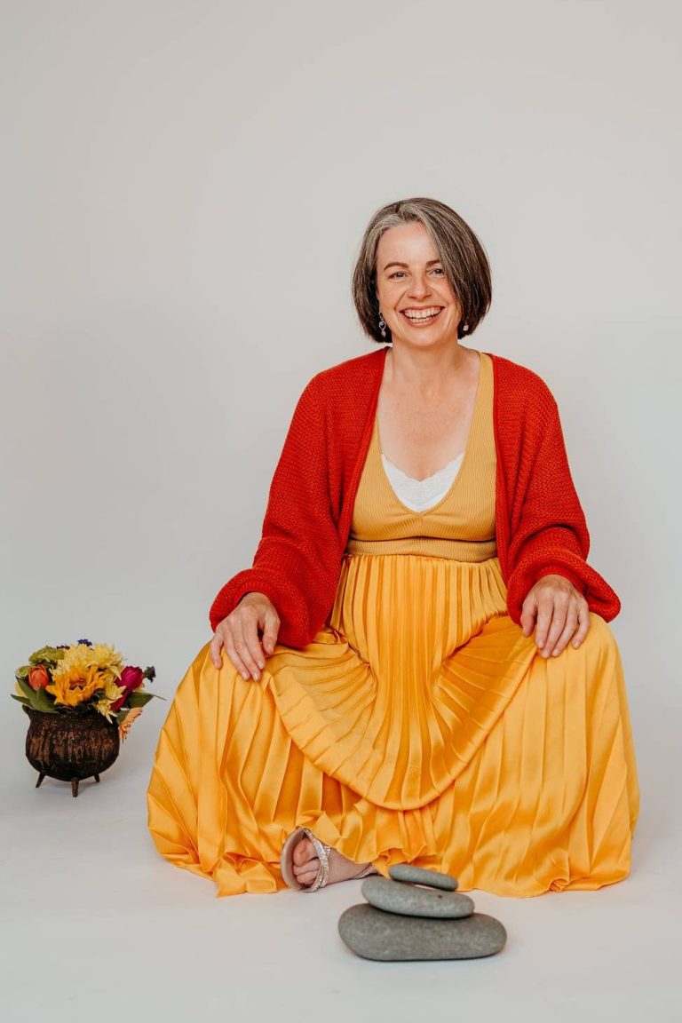 Golden dress with smiles A photo of Kirsty crossed legged in golden dress smiling.